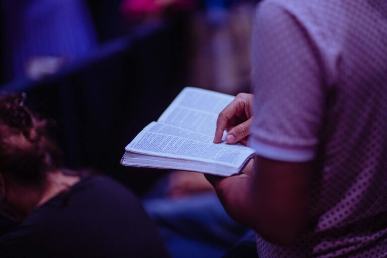A focused moment of a person engaged in reading a Bible inside a church.