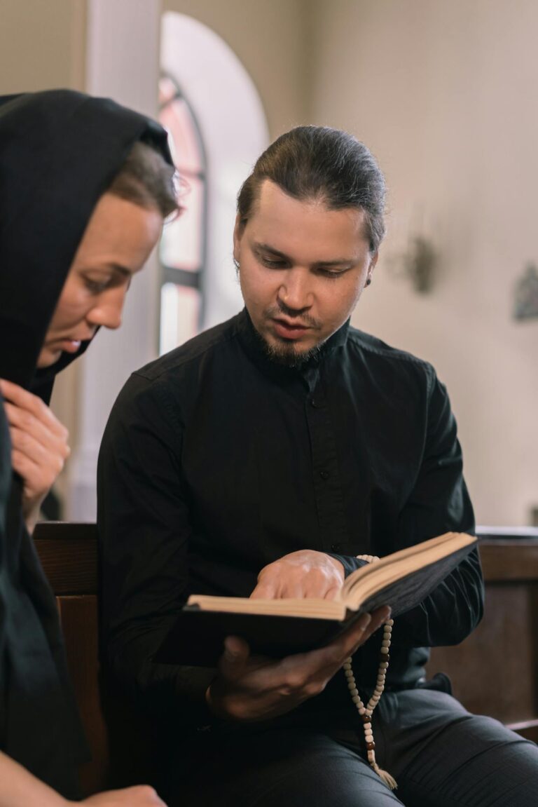 A priest guiding a parishioner through the Bible inside a church setting.